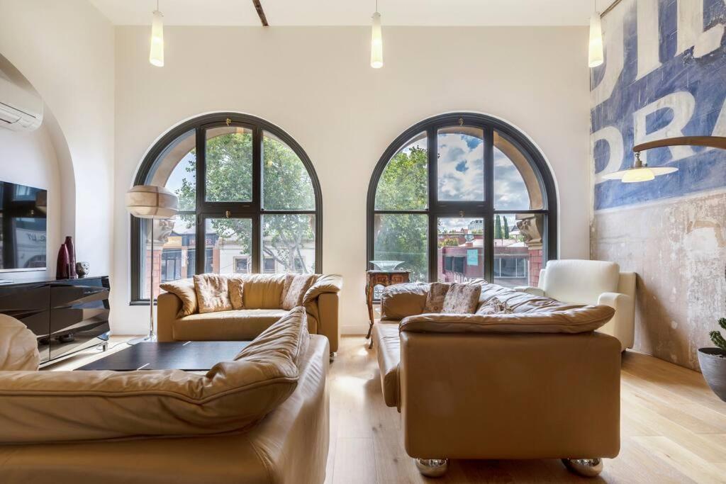 a living room with two couches and windows at The Sophia in Melbourne