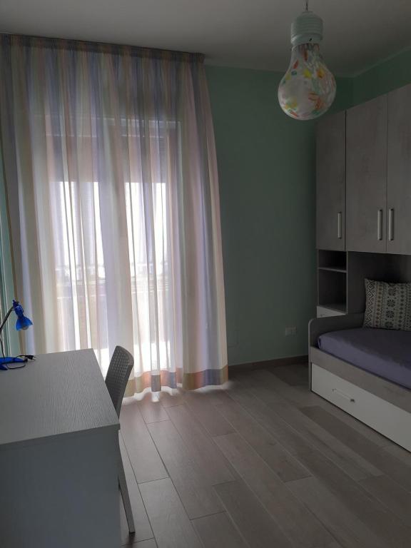 um quarto com uma cama, uma mesa e uma janela em Luli Holidays Paestum em Paestum