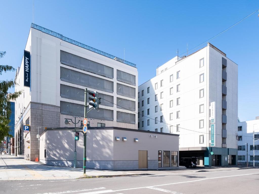 eine Ampel auf einer Stadtstraße mit Gebäuden in der Unterkunft Tabist THE GREEN OTARU in Otaru