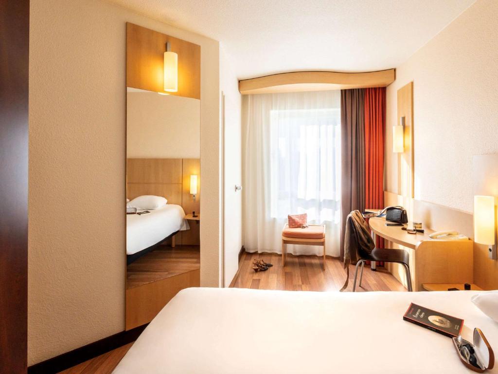 a hotel room with a bed and a desk at ibis Antwerpen Centrum in Antwerp