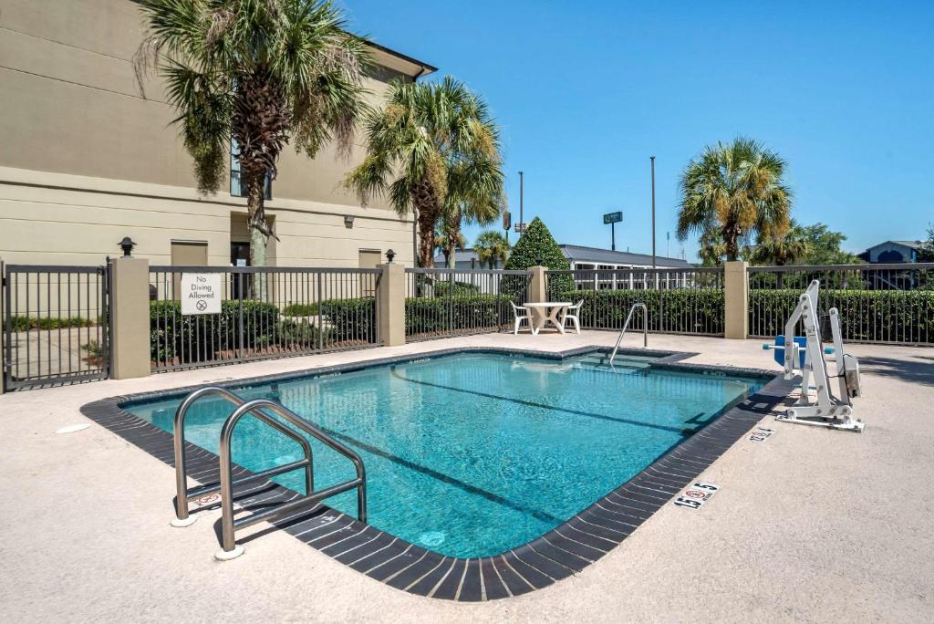 モービルにあるComfort Suites Mobile West Tillmans Cornerの建物の隣にある小さなスイミングプール(金属製のレール付)
