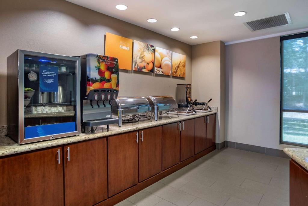 モービルにあるComfort Suites Mobile West Tillmans Cornerのキッチン(カウンター、スツール、冷蔵庫付)