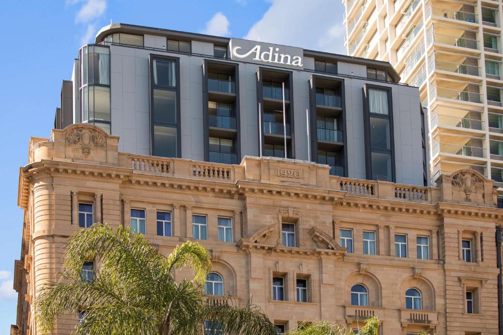 a building with a sign on top of it at Adina Apartment Hotel Brisbane in Brisbane