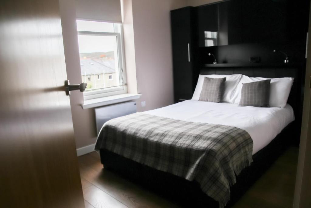 a bedroom with a bed and a window at Nort Bode Apartments in Lerwick