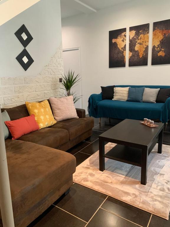 a living room with two couches and a coffee table at Villa Tenjin Chambre 15 in Bondy