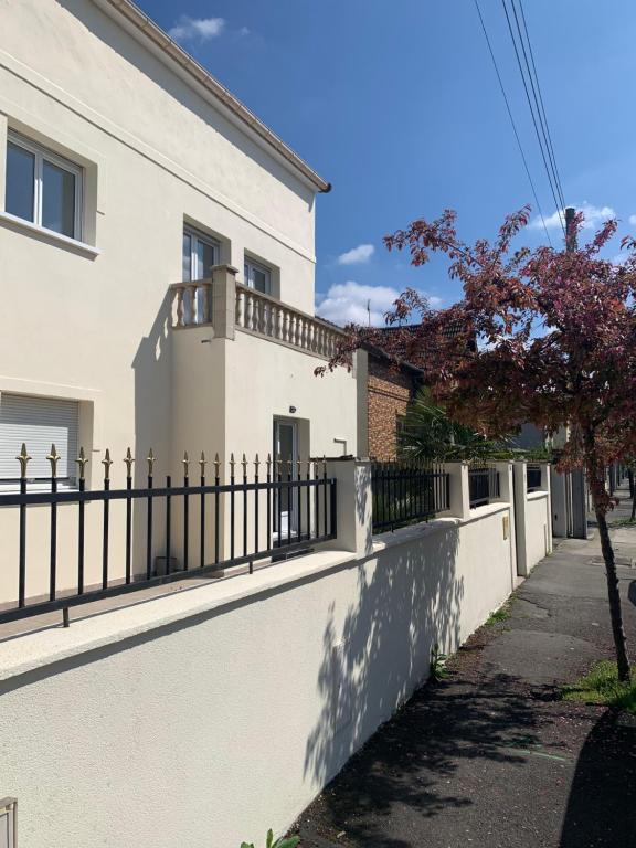 a fence in front of a white house at Villa Tenjin Chambre 15 in Bondy