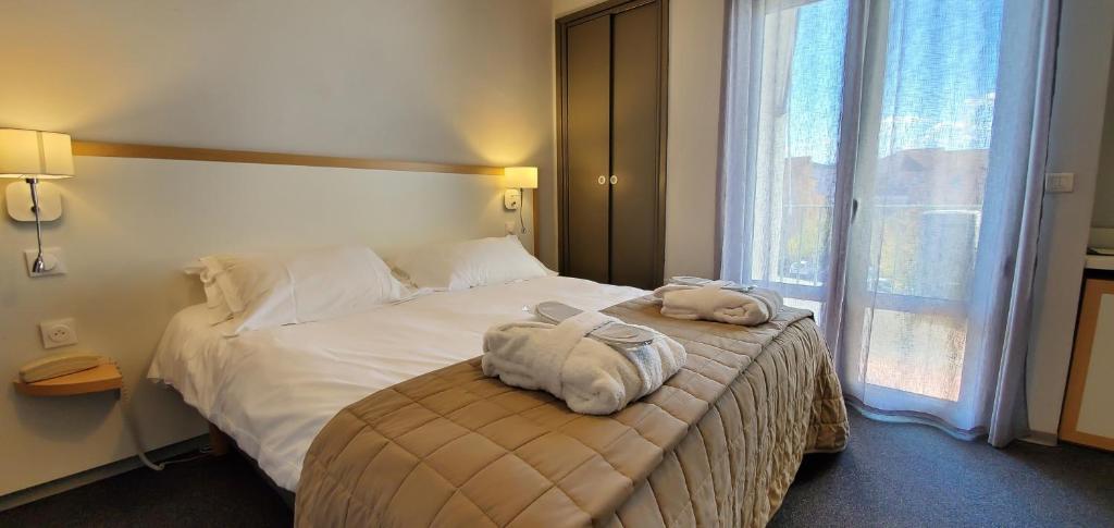 a hotel room with a bed with two stuffed animals on it at Hôtel Restaurant Atrachjata in Aléria