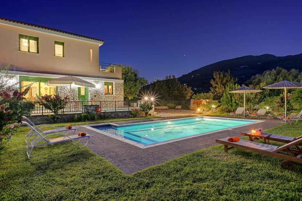 a house with a swimming pool in the yard at Villa Syriti in Skala