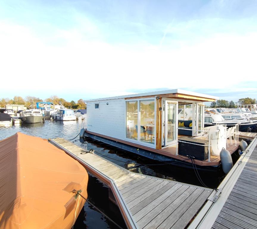 ein winziges Haus auf einem Boot in einem Yachthafen in der Unterkunft Blue Mind, heerlijk vakantiehuisje op het water: in Vinkeveen