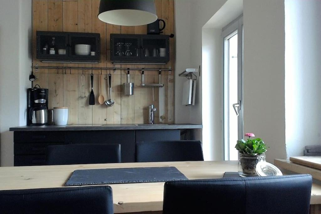 a kitchen with a wooden table with chairs and a dining room at Herberge. 46 in Garmisch-Partenkirchen