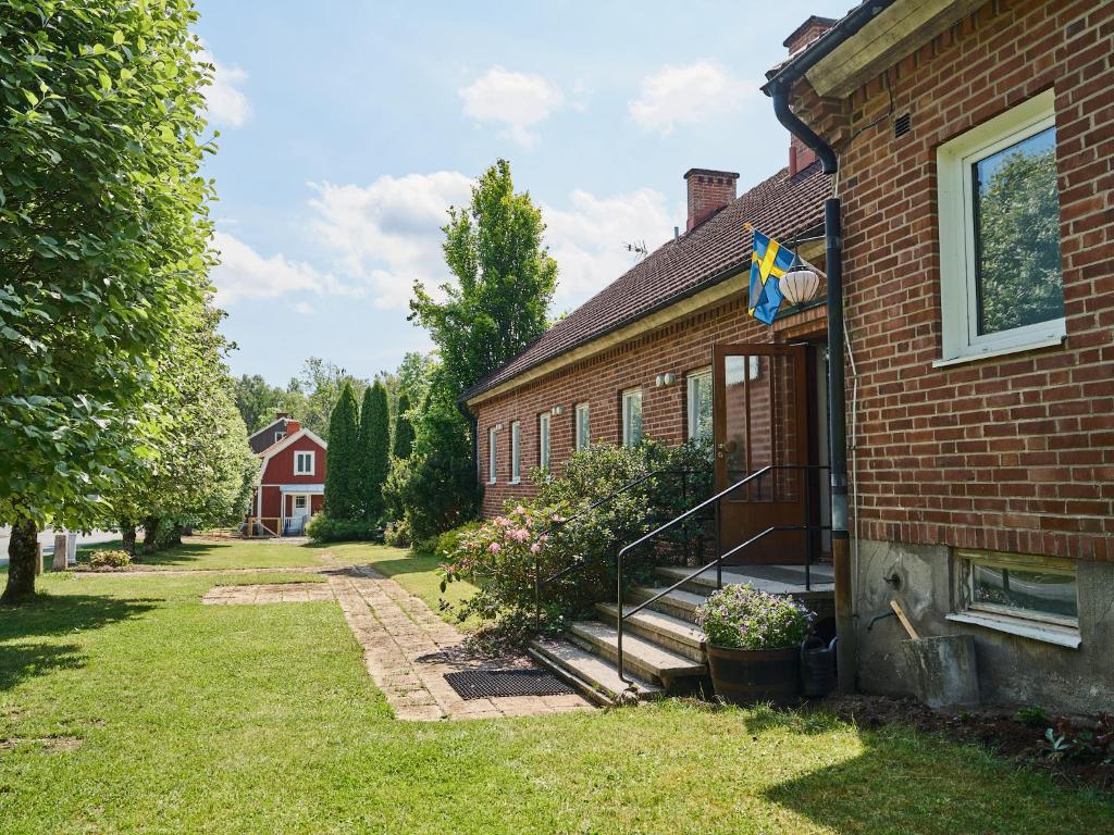Una casa de ladrillo con una bandera en el costado. en Herrestad Bed & Guestroom, en Värnamo