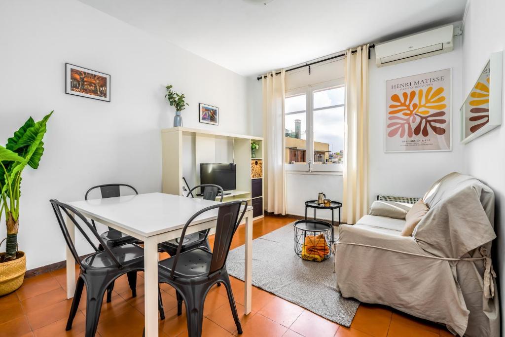 a living room with a table and chairs and a couch at Arc De Triomf - Solar & Spacious in Barcelona