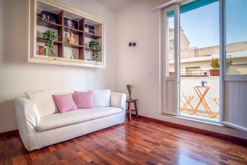 uma sala de estar com um sofá branco e uma janela em Appartamento nel cuore della città em Livorno