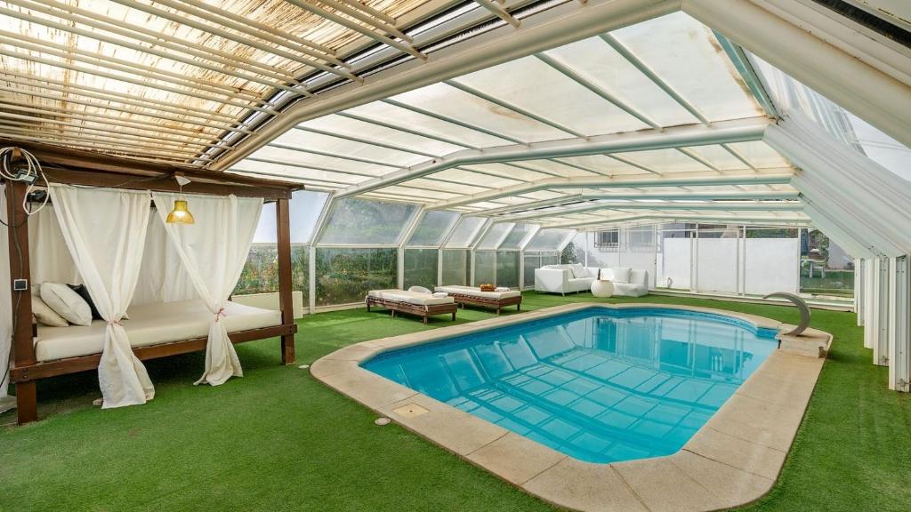 una piscina en una casa con techo abierto en Villa de los Sueños Atarfe by Ruralidays en Atarfe