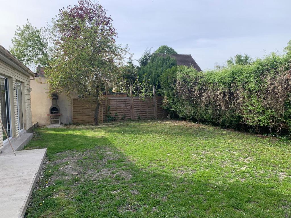 a backyard with a fence and a yard withgrass at Villa Tenjin Chambre 17 in Bondy