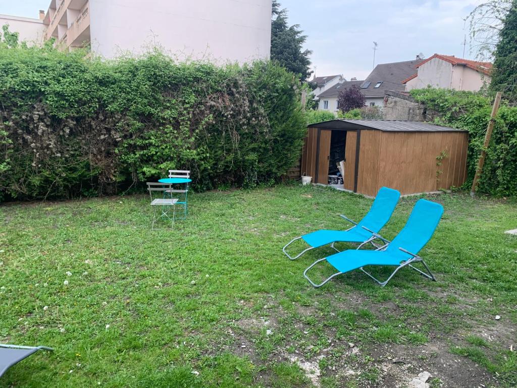 two chairs and a table in a yard at Villa Tenjin Chambre 17 in Bondy