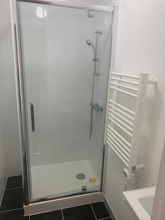 a shower with a glass door in a bathroom at Villa Tenjin Chambre 17 in Bondy