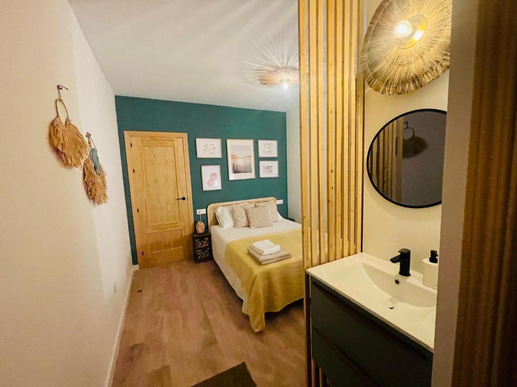 een kleine slaapkamer met een bed en een wastafel bij Casa del palmar junior in Valencia