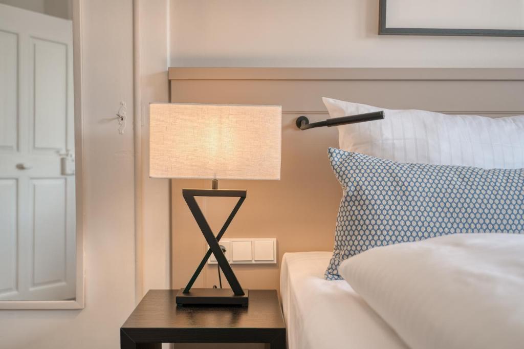 a lamp sitting on a table next to a bed at Hotel Eisenhut in Rothenburg ob der Tauber