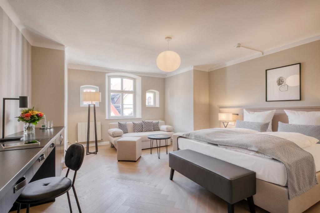 a bedroom with a large bed and a living room at Hotel Eisenhut in Rothenburg ob der Tauber