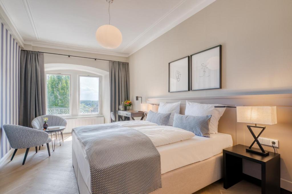 a bedroom with a large bed and a table and chairs at Hotel Eisenhut in Rothenburg ob der Tauber