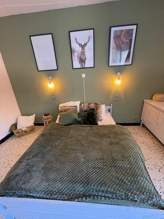 un dormitorio con una cama con un perro sentado en ella en Chez Tatie Ménie, en Fraissé-des-Corbières