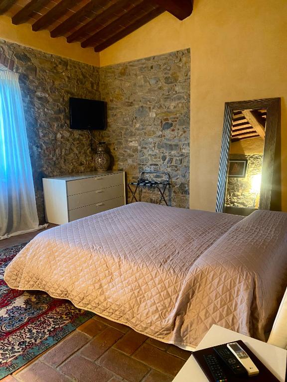 a bedroom with a bed and a stone wall at Room in BB - Sottotono Agriturismo with swimming pool on Florence surrounded by greenery in Carmignano