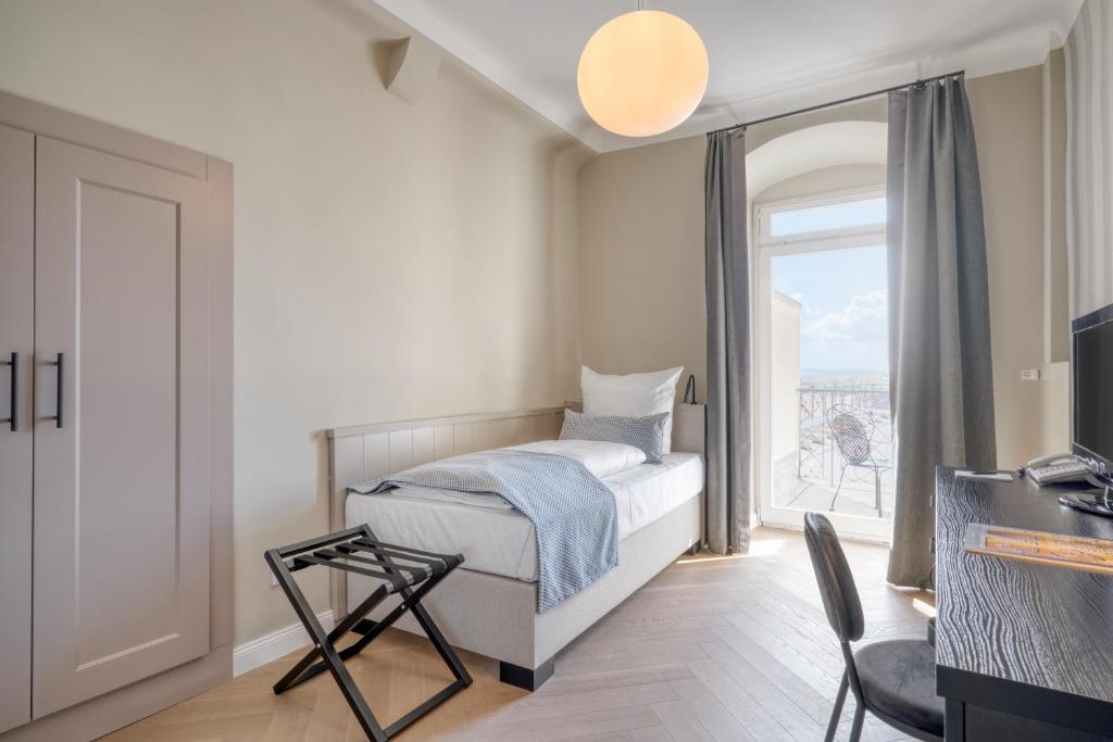 a bedroom with a bed and a window at Hotel Eisenhut in Rothenburg ob der Tauber