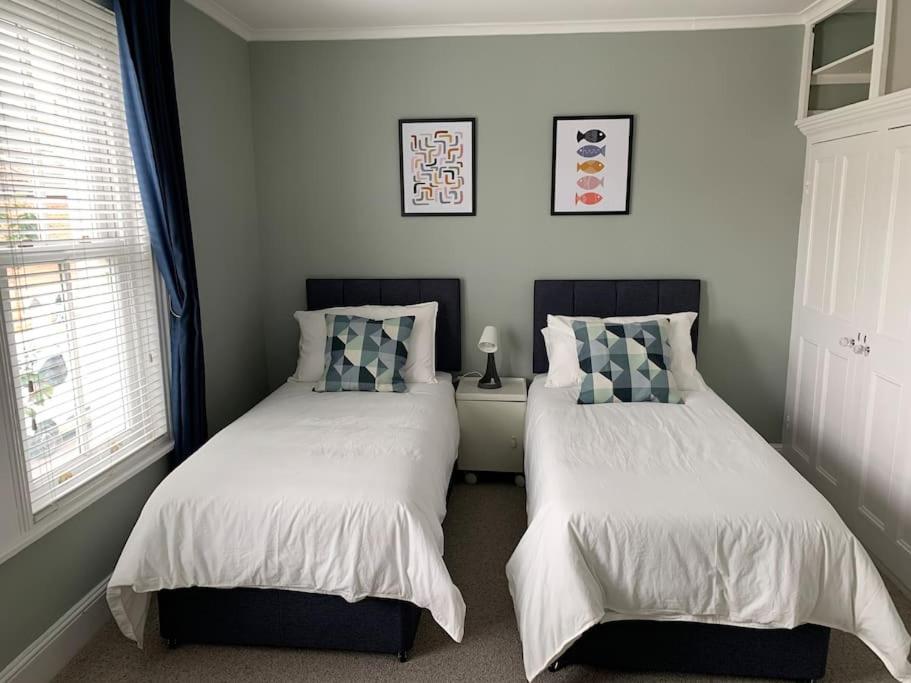 um quarto com 2 camas e uma janela em Napier - A Beautiful House in the best Southsea location em Portsmouth