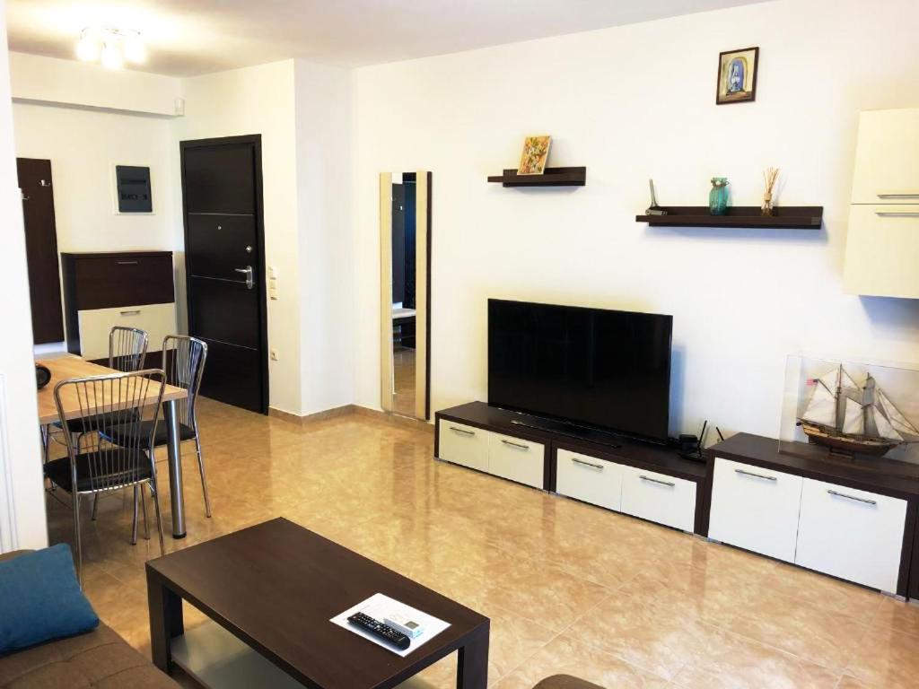 a living room with a television and a table at Bella Vera Apartments 2 in Limenas
