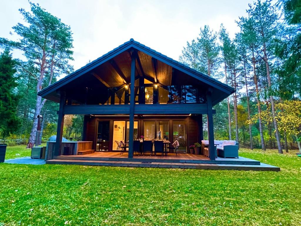 a house with a large deck in the grass at Jõiste Beach Villa in Jõiste