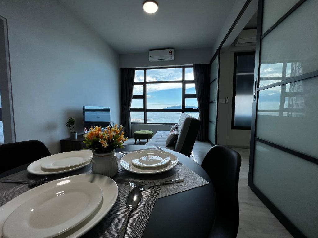 ein Esszimmer mit einem Tisch mit Tellern und Küchenutensilien in der Unterkunft Dreams Suites II, Jesselton Quay in Kota Kinabalu