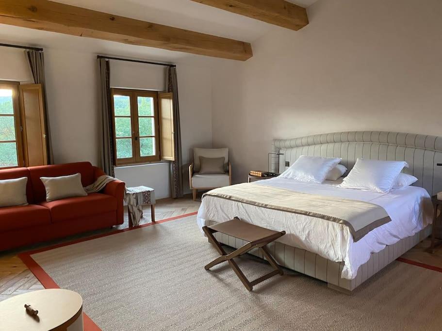 een slaapkamer met een bed en een rode bank bij Magnifique villa dans propriété au havre de paix in Plan-de-la-Tour