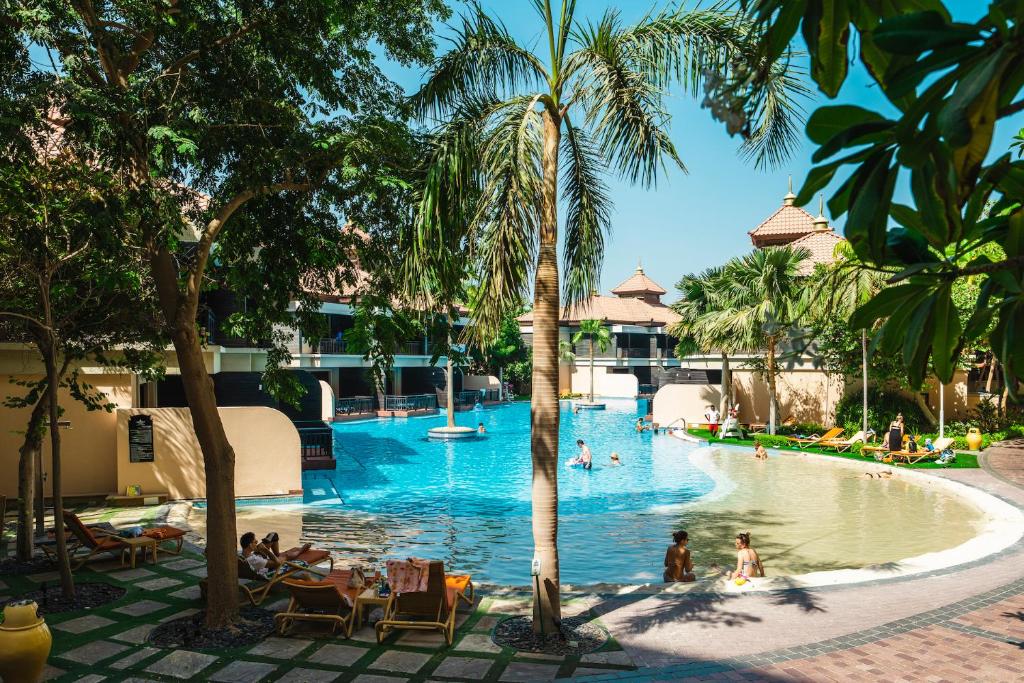 杜拜的住宿－Relaxing 1 bedroom apartment at 5 Star Resort，度假村的游泳池,人们在里面游泳