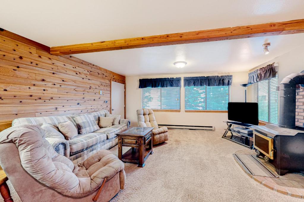 a living room with couches and a flat screen tv at Chalet Village #24 in Brian Head