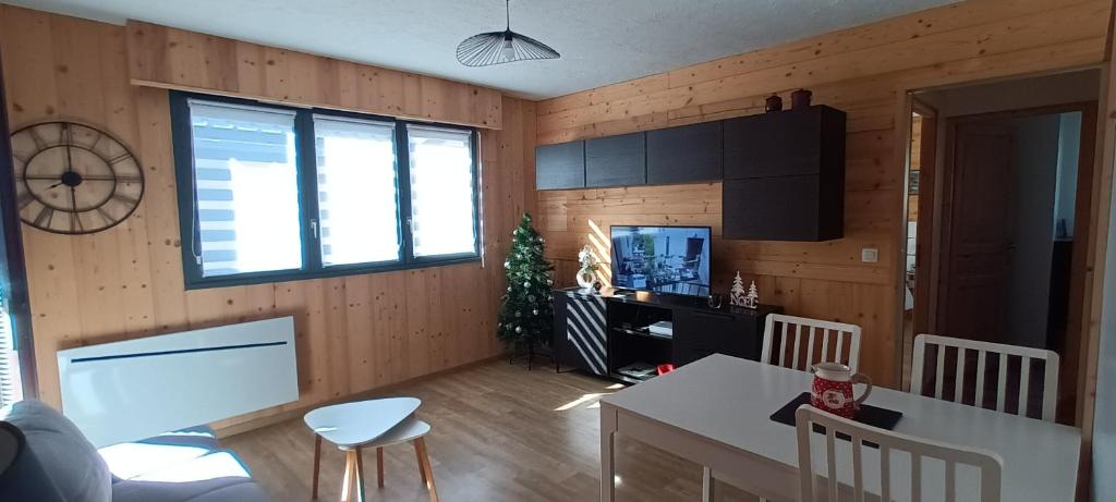 a living room with wooden walls and a kitchen with a table at Le Flory'lège in Saint-Gervais-les-Bains