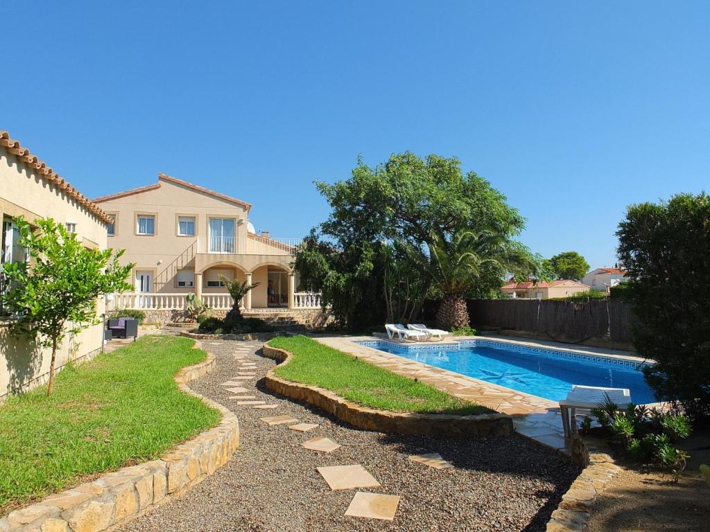 a backyard with a swimming pool and a house at Villa Libelula in L'Ametlla de Mar