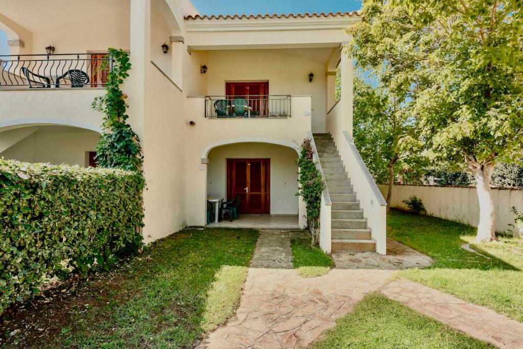 een huis met een trap en een rode deur bij Graziosi appartamenti a Budoni con aria condizionata a soli 300 mt dal mare in Budoni