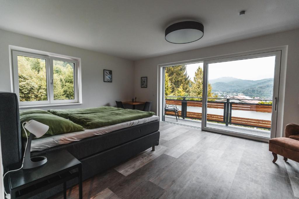 a bedroom with a large bed and large windows at Seeblick Homes in Fuschl am See