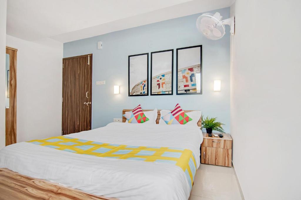 1 dormitorio con 1 cama blanca grande con almohadas a rayas en Hotel Yadvik en Chennai