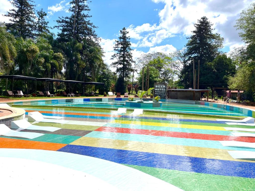 a pool with a rainbow floor in a park at Beer Hotel Iguazú in Puerto Iguazú