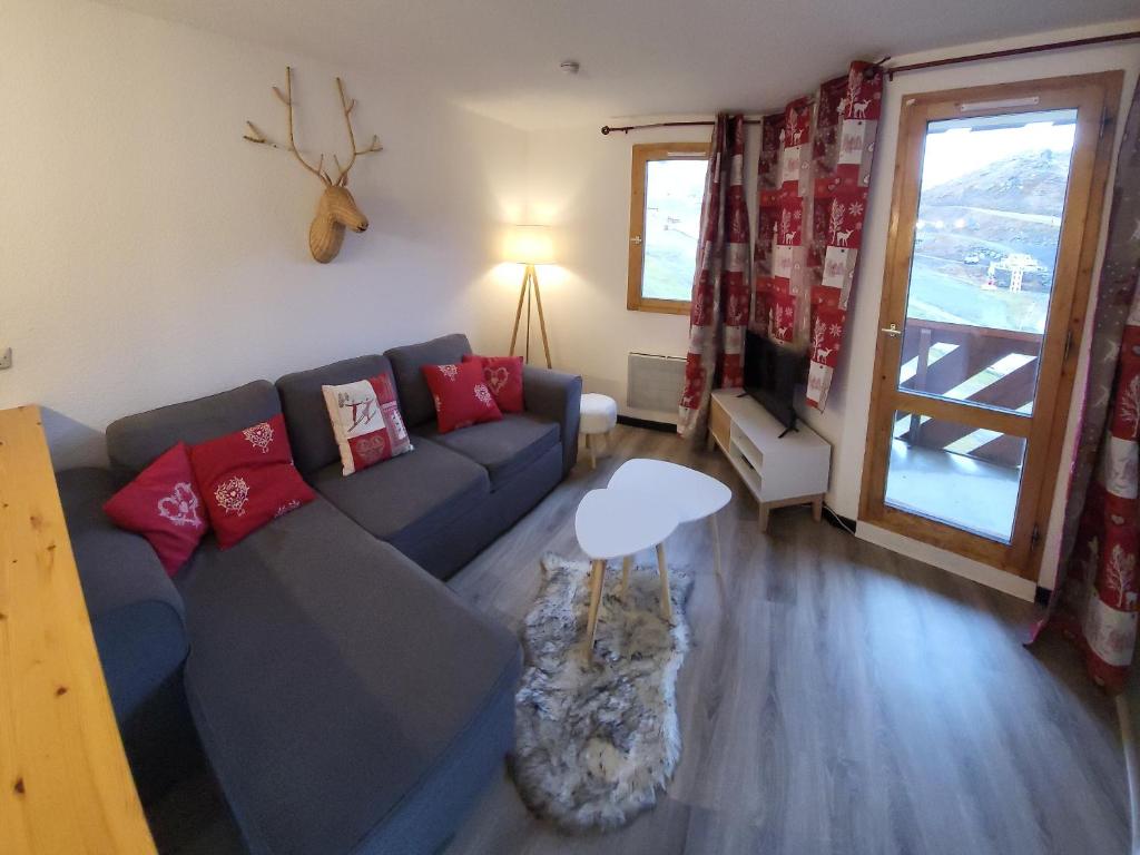 a living room with a couch and a table at Cosy Val Tho ski aux pieds in Val Thorens