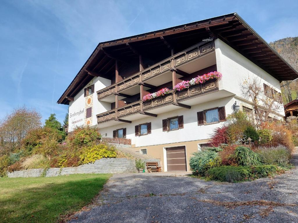 a building with a balcony with flowers on it at Haus Seeberghof by Globalimmoservice in Millstatt