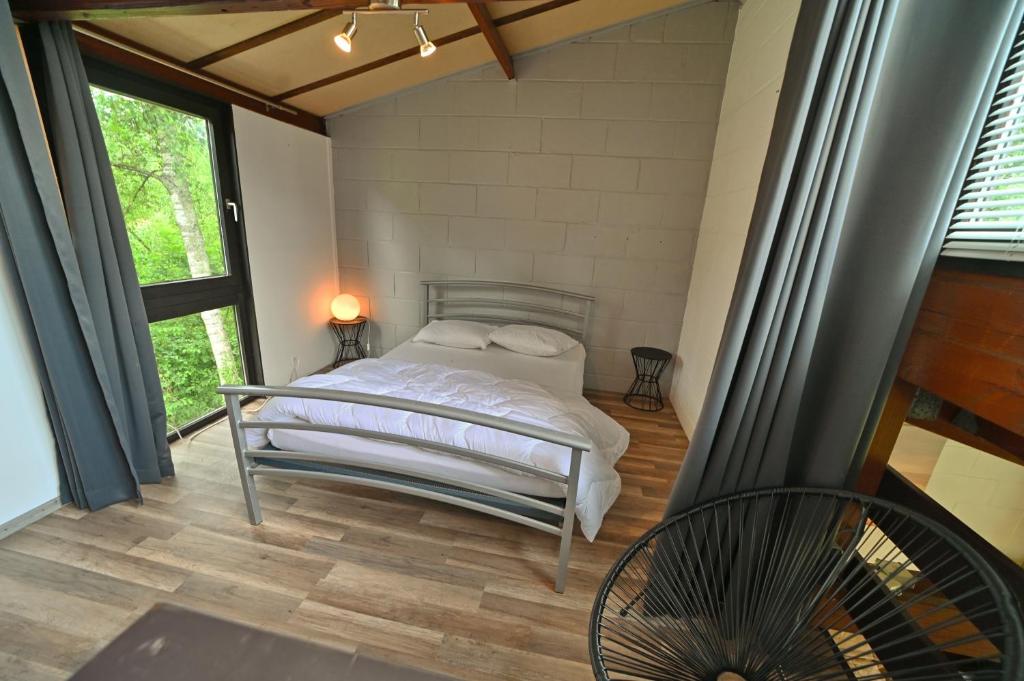 sypialnia z łóżkiem w pokoju z oknami w obiekcie Horlès 114 w mieście Virton