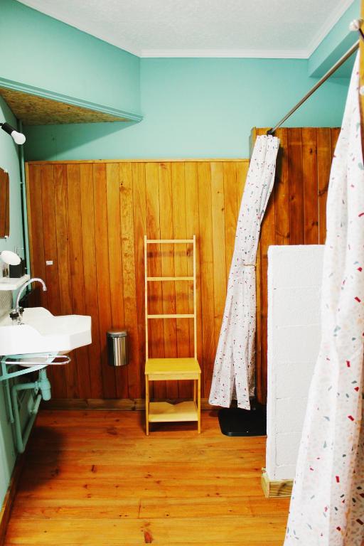 a bathroom with a wooden floor and a wooden chair at Eau Berges in Vicdessos
