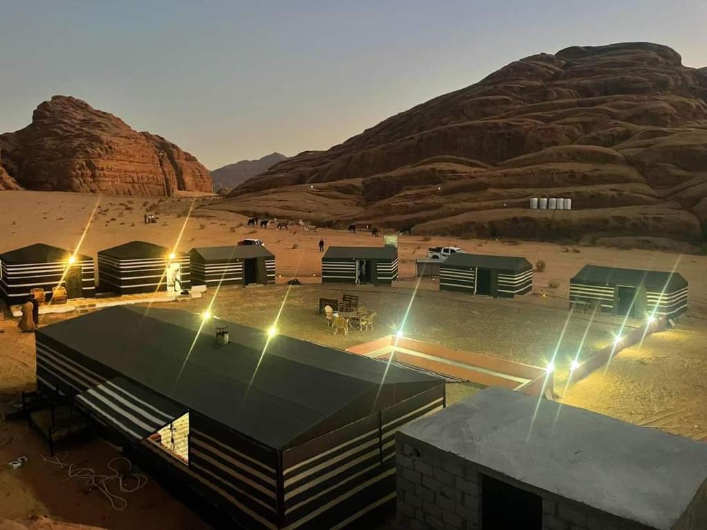 a building in the middle of a desert with a mountain at Bronze Mountains Camp Wadi Rum in Aqaba