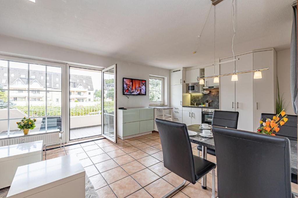 a kitchen and dining room with a table and chairs at fewo1846 Strandresidenz Wassersleben - Nordi - komfortables Studioapartment mit Balkon und Meerblick in Harrislee