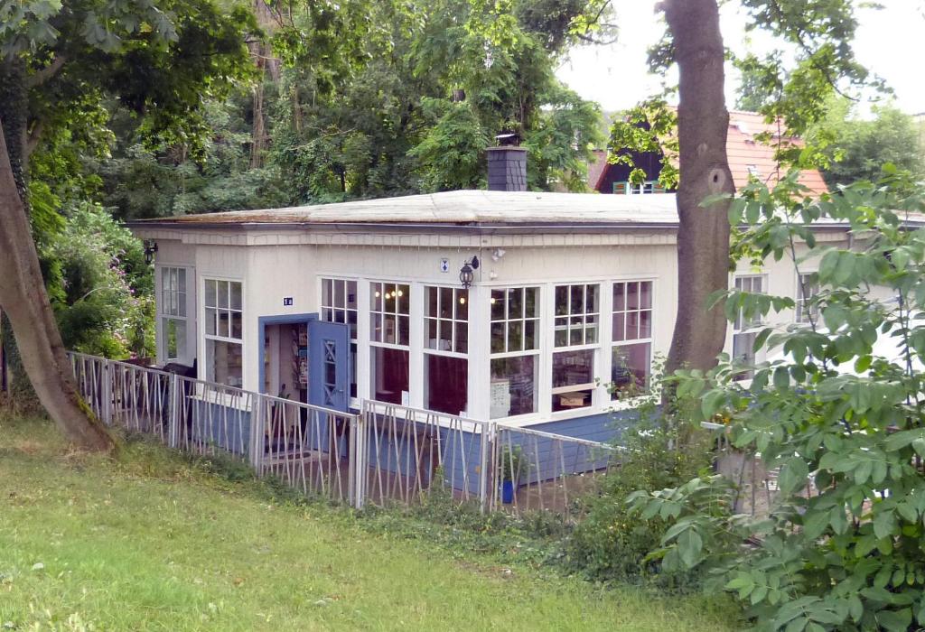 a white house with a fence in a yard at FeWo im Sahneröschen in Magdeburg