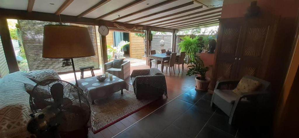 a living room with a bed and a table and chairs at Appartement de charme à côté de la plage in La Saline les Bains