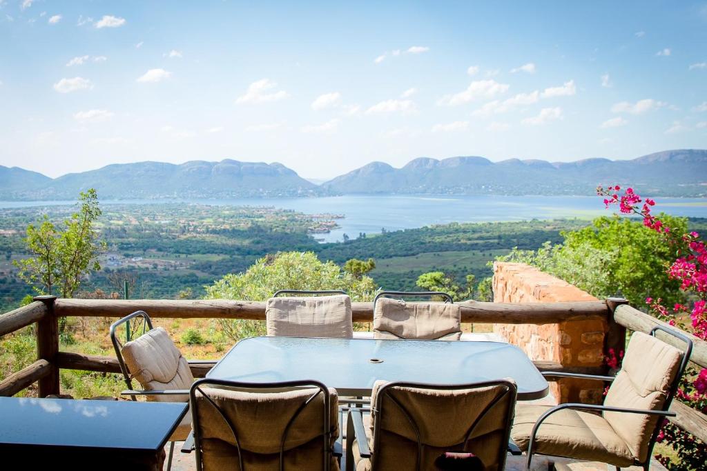 a table and chairs on a balcony with a view at Koraalboom at Benlize in Hartbeespoort